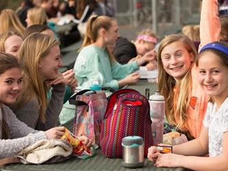 Students eating lunch on a table outside
